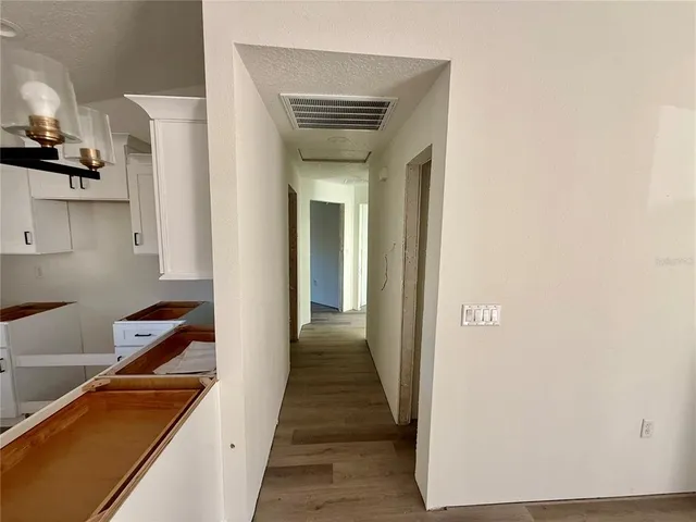 a view of kitchen with stainless steel appliances granite countertop cabinets and wooden floor