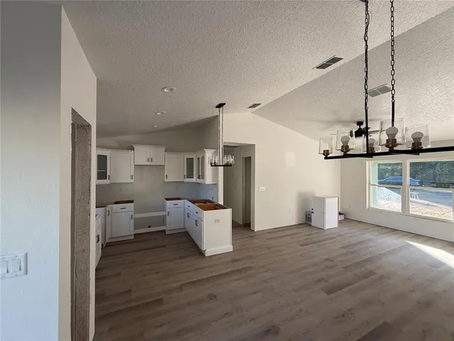 a living room with furniture and a kitchen view