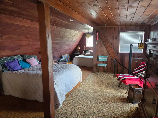 a bed sitting in a bedroom next to a larger window