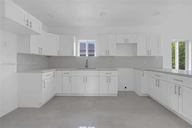 a kitchen with cabinets appliances a sink and a window
