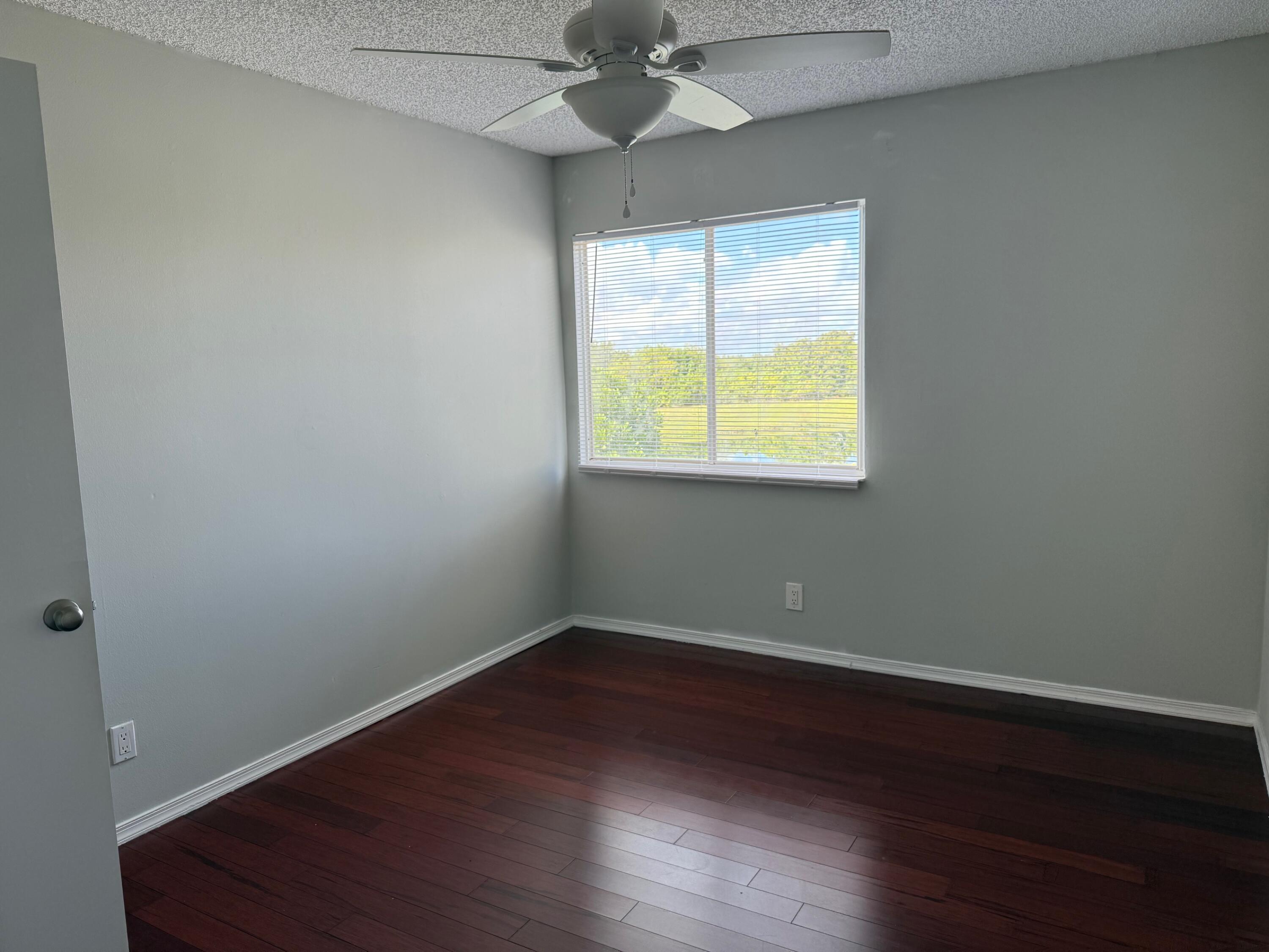 22492 Middletown Drive Boca Raton, FL 33428 - Photo 15 of 35 an empty room with wooden floor and windows