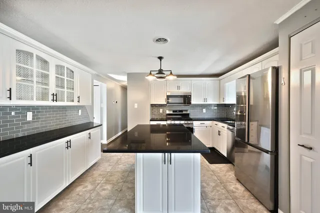 a kitchen with granite countertop a sink a stove and cabinets