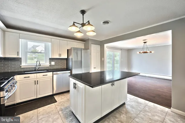 a kitchen with a center island appliances and cabinets