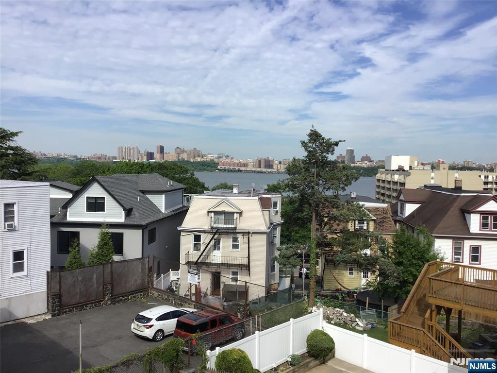 21 Valley Place, Unit 3 Edgewater, NJ 07020 - Photo 11 of 18 a view of a white house with a big yard and large tree