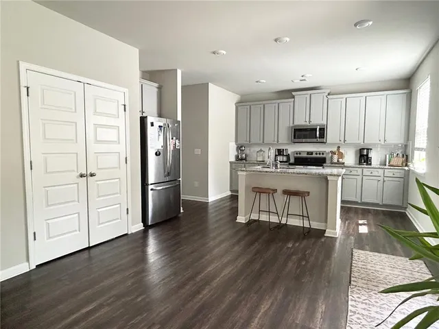 a kitchen with stainless steel appliances a stove a sink a refrigerator and cabinets