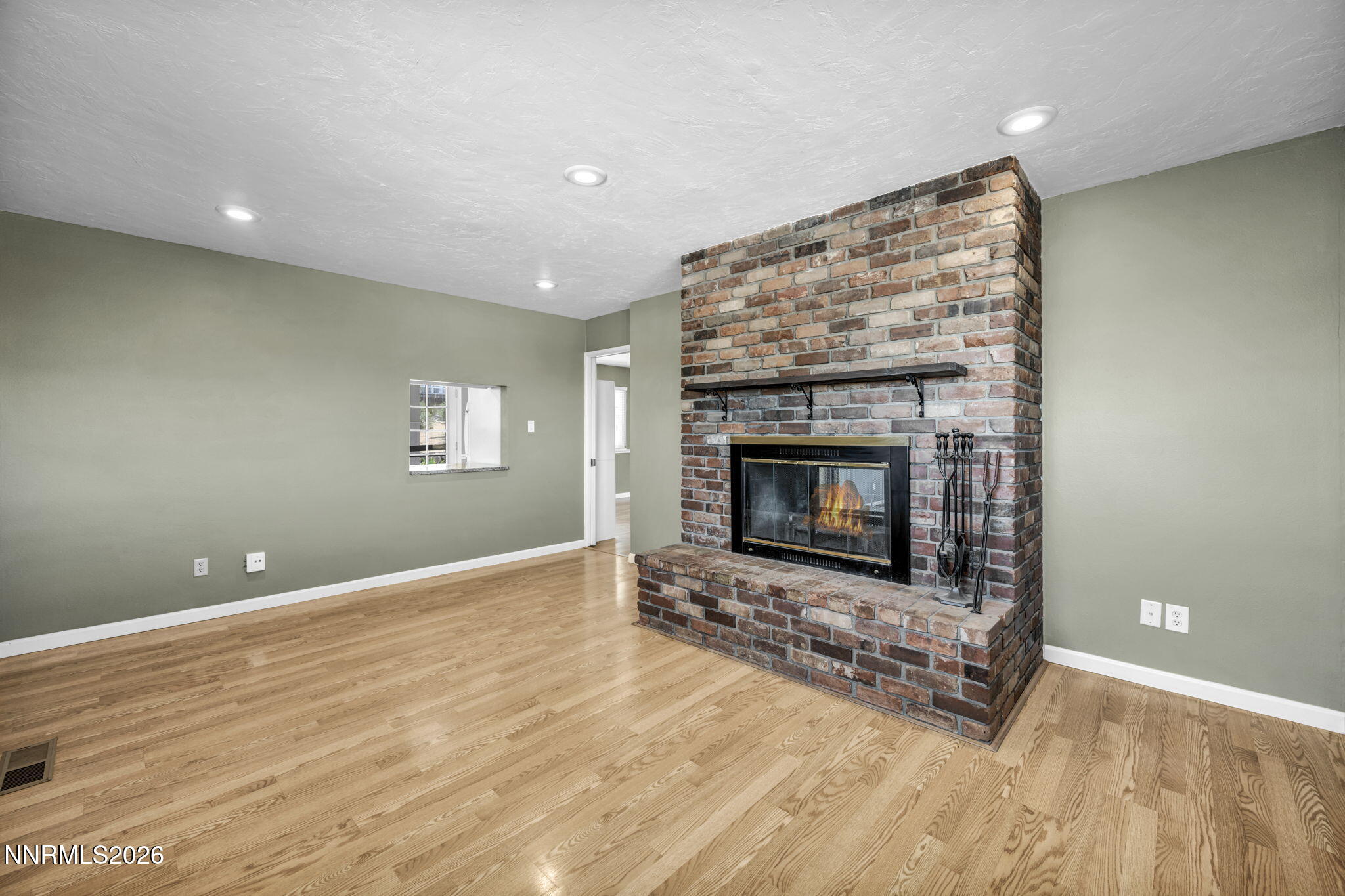 14190 Rim Rock Drive Reno, NV 89521 - Photo 13 of 68 an empty room with wooden floor and fireplace