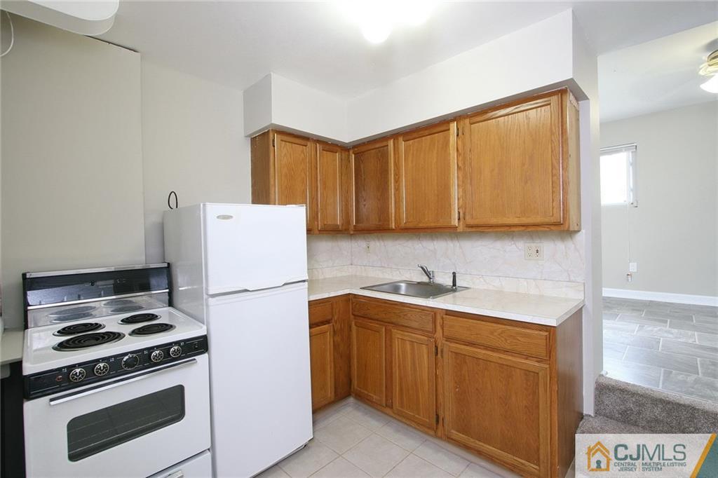 15 Leland Road Edison, NJ 08817 - Photo 14 of 25 a kitchen with a white cabinets and white appliances