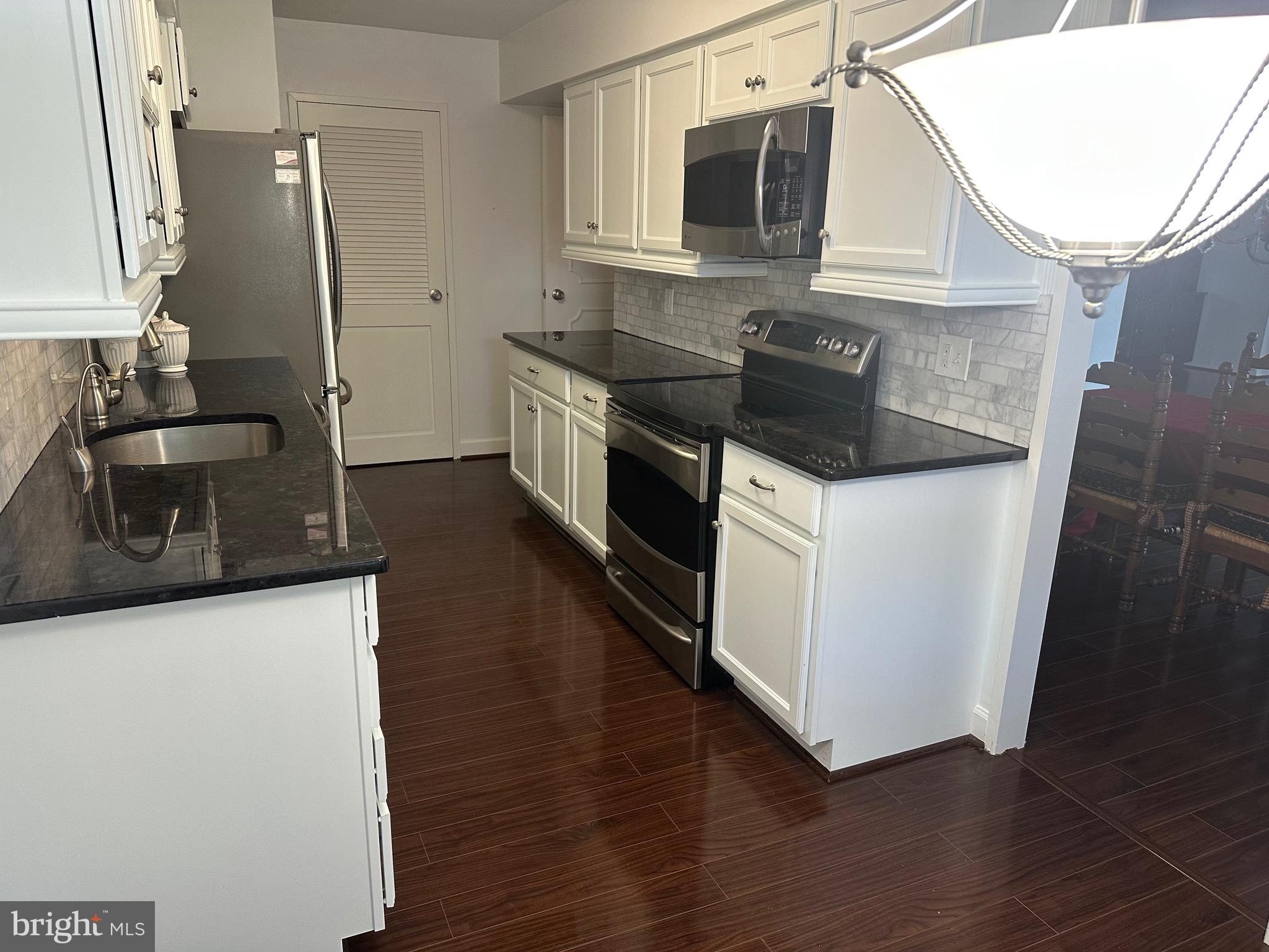 41 Conshohocken State Road, Unit 109 Bala Cynwyd, PA 19004 - Photo 7 of 23 a kitchen with stainless steel appliances granite countertop a sink stove and microwave