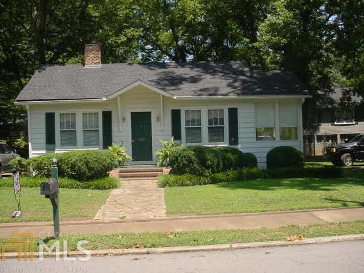 a front view of a house with a yard and outdoor seating
