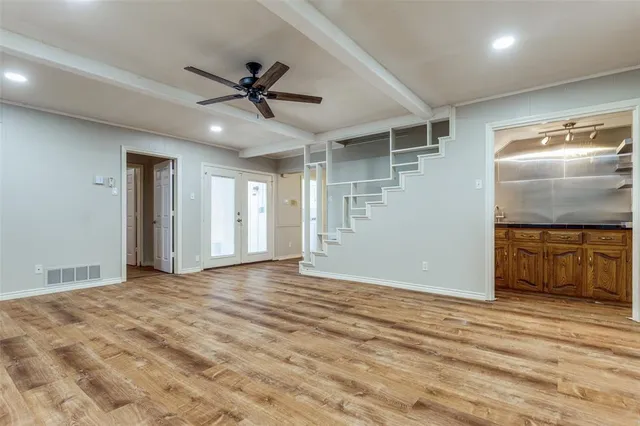 a view of an empty room and kitchen view