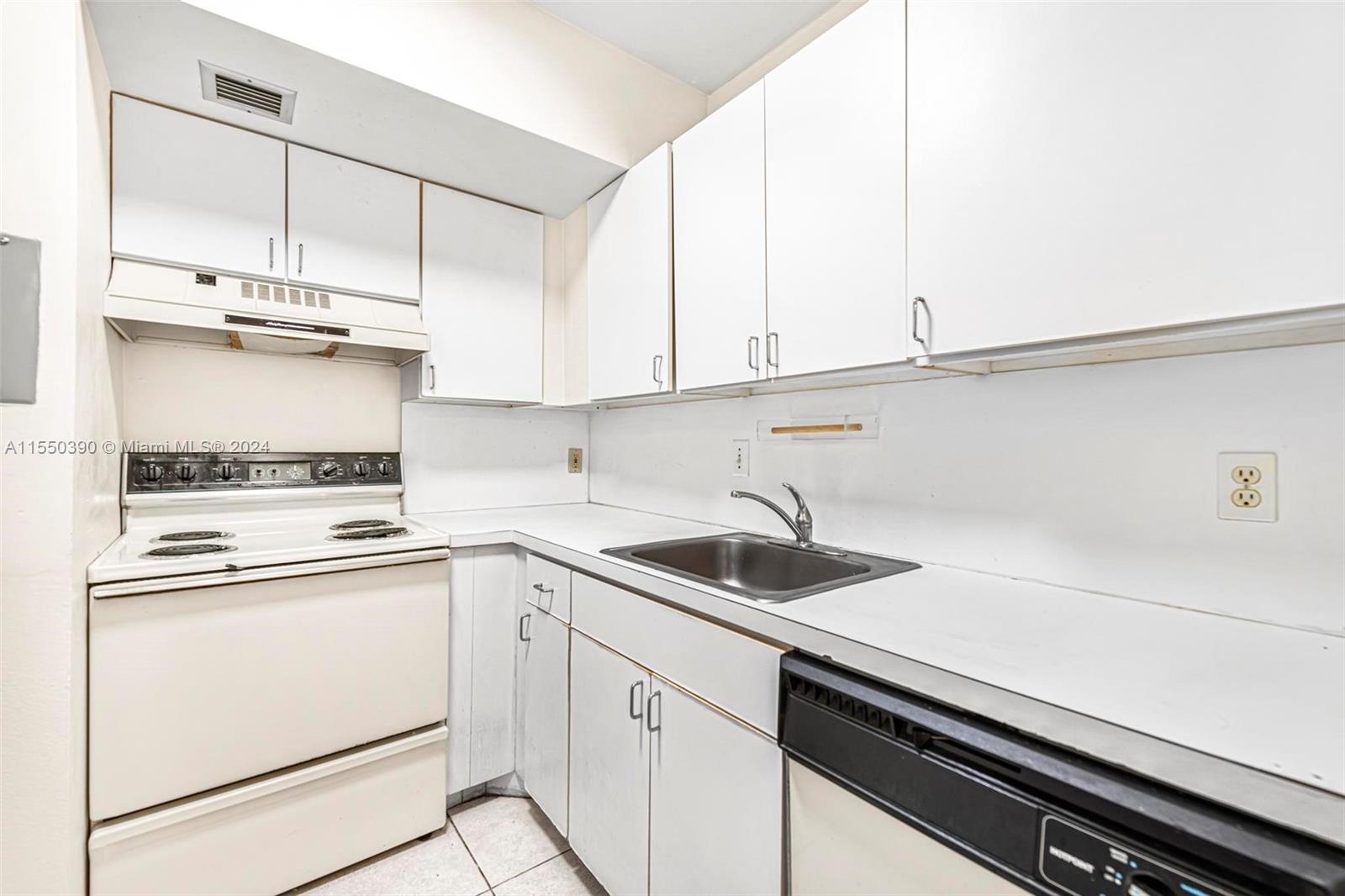 9107 Southwest 137th Terrace, Unit 14 Miami, FL 33186 - Photo 13 of 25 a kitchen with appliances cabinets and a sink