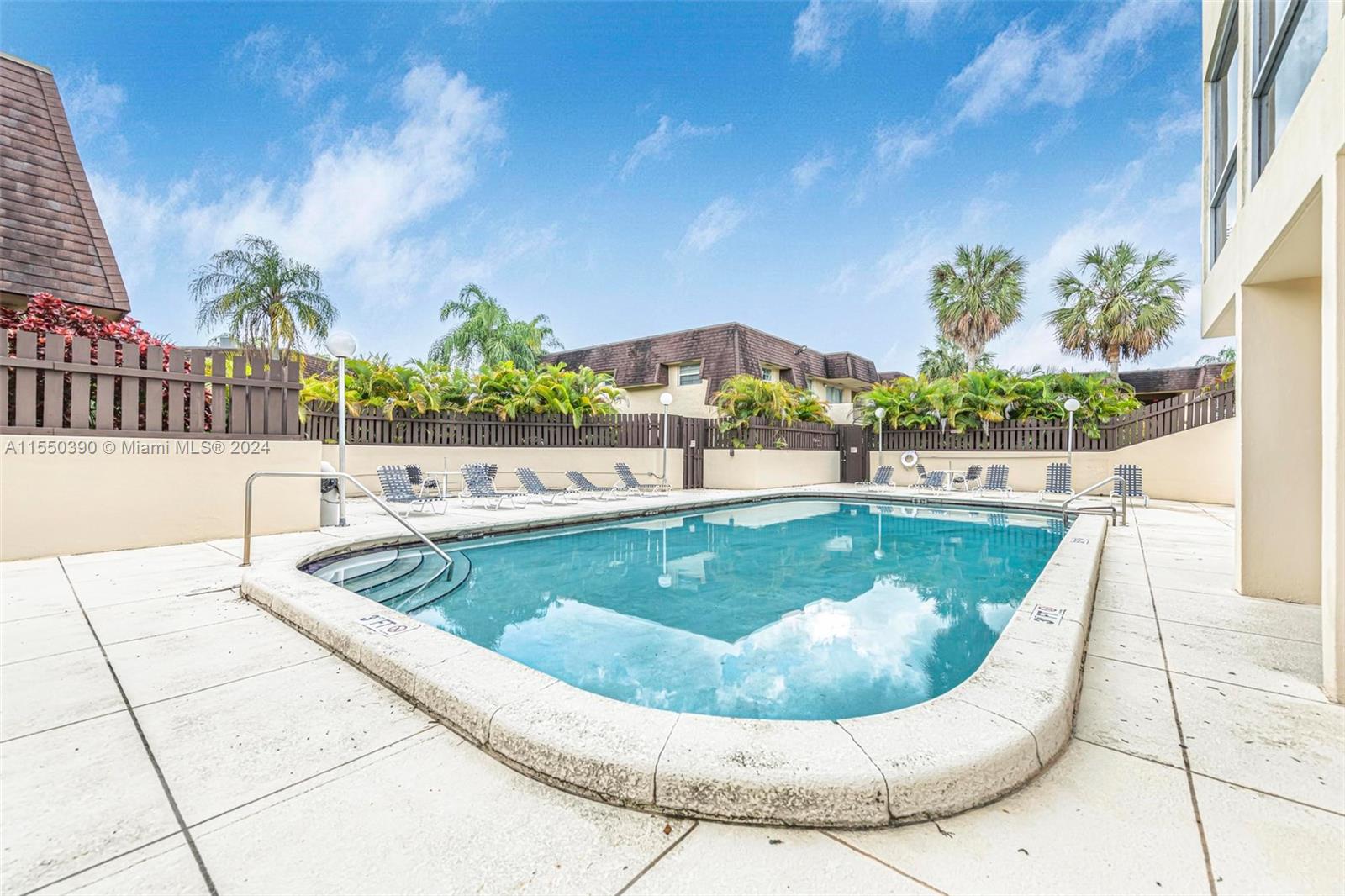 9107 Southwest 137th Terrace, Unit 14 Miami, FL 33186 - Photo 24 of 25 a view of a swimming pool with a yard