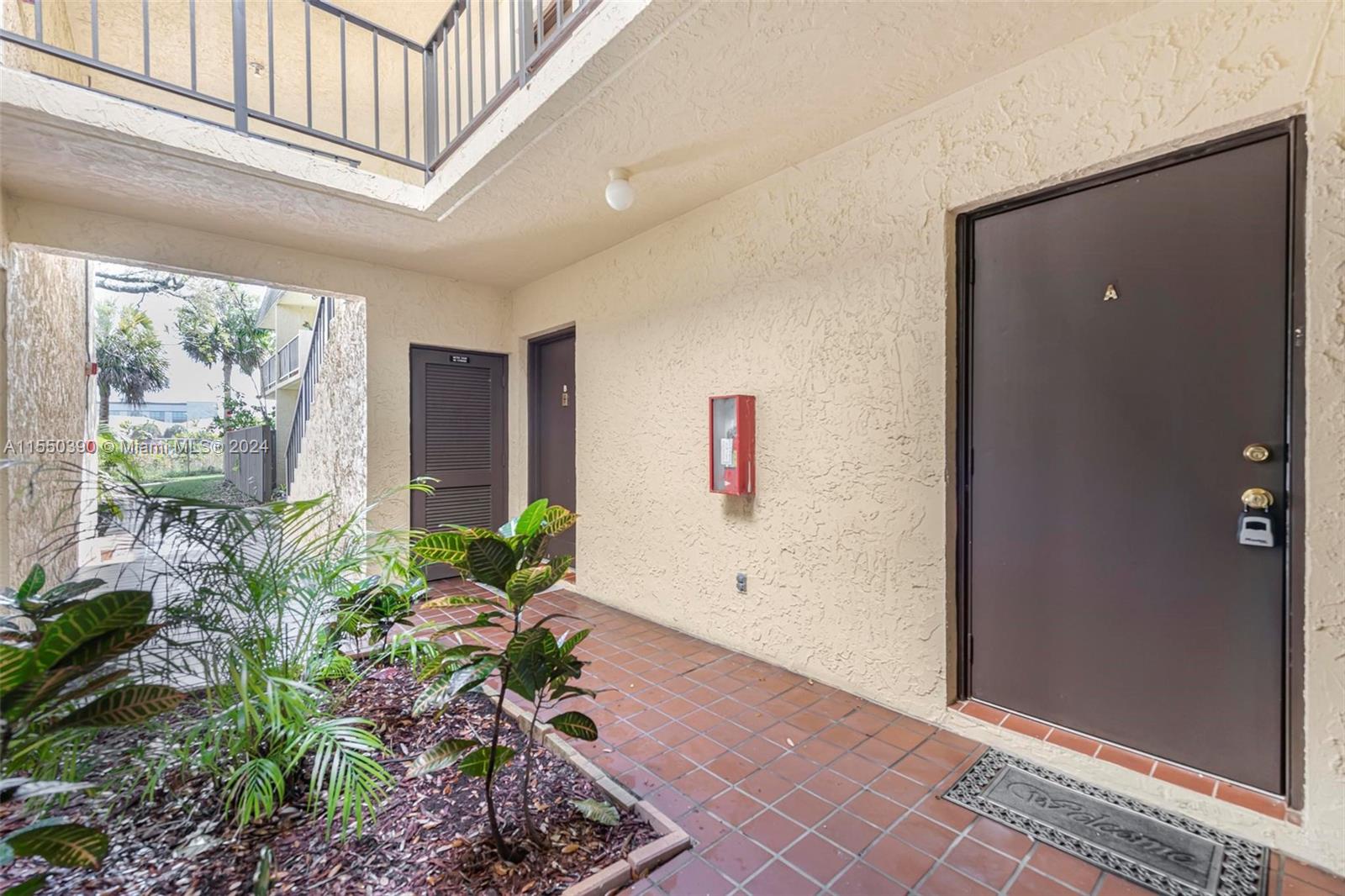 9107 Southwest 137th Terrace, Unit 14 Miami, FL 33186 - Photo 4 of 25 a view of entryway with flower plants