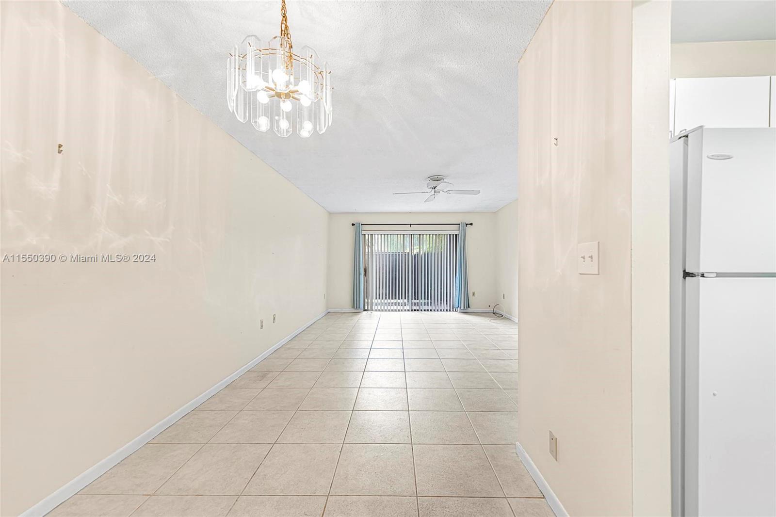 9107 Southwest 137th Terrace, Unit 14 Miami, FL 33186 - Photo 6 of 25 a view of an empty room with a chandelier