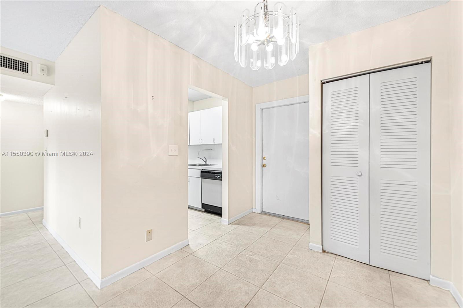 9107 Southwest 137th Terrace, Unit 14 Miami, FL 33186 - Photo 8 of 25 a view of a hallway with a chandelier