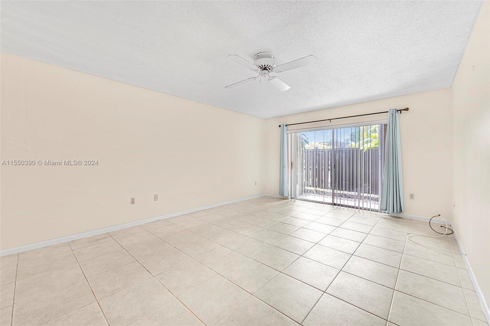 9107 Southwest 137th Terrace, Unit 14 Miami, FL 33186 - Photo 9 of 25 a view of an empty room with a window