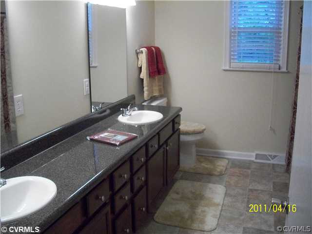1211 Covington Road Colonial Heights, VA 23834 - Photo 10 of 11 a bathroom with a sink a toilet and mirror