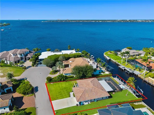 an aerial view of ocean and residential houses with outdoor space