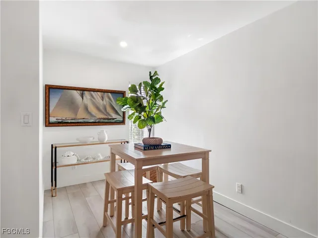 a living room with couches and a dining table with wooden floor