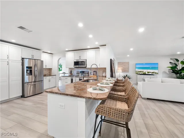a large kitchen with cabinets stainless steel appliances and a counter space