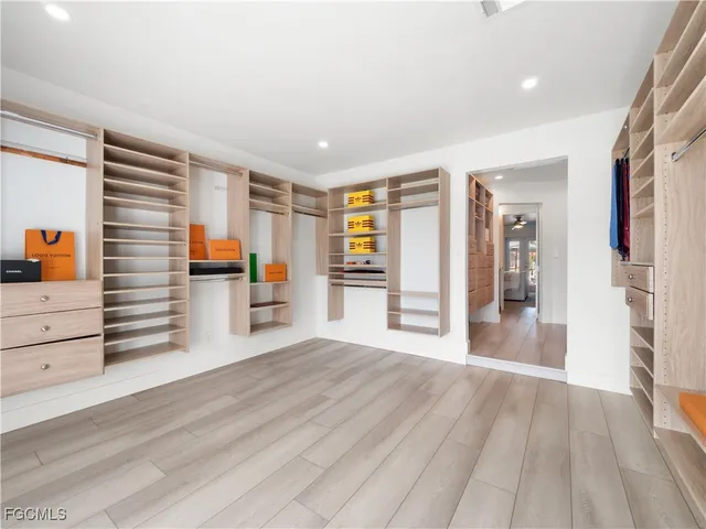 a bedroom with a large bed wooden floor and window