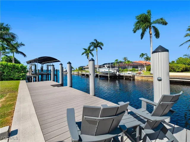 a view of a backyard with couches under an umbrella