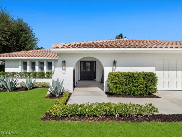 a front view of a house with a garden