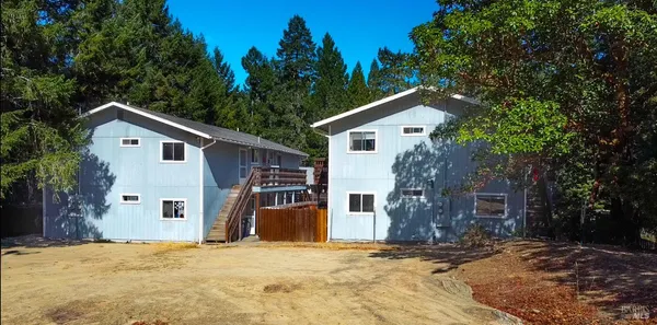 a view of a house with a yard and tree
