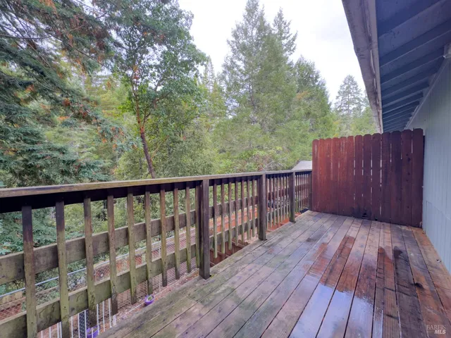 a balcony with wooden floor and trees