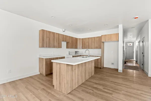 a kitchen with a sink cabinets and wooden floor