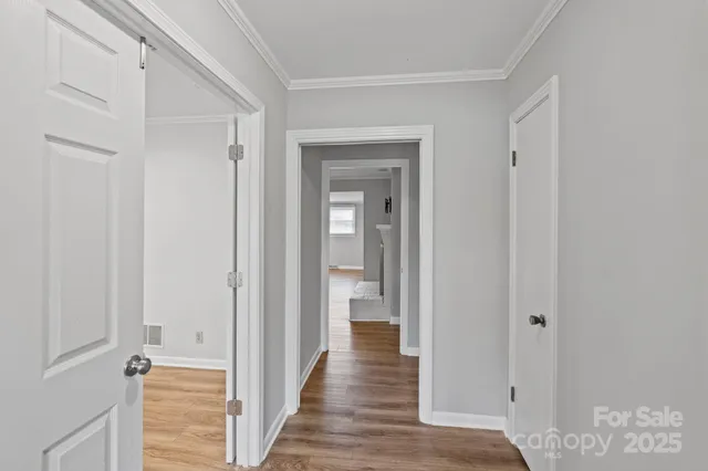 a view of a hallway with wooden floor and closet