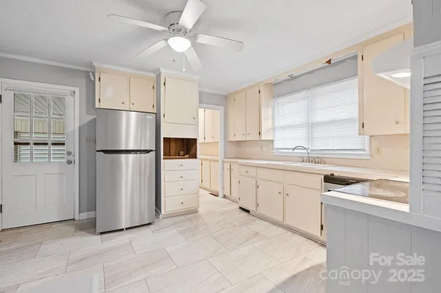 a kitchen with white cabinets and refrigerator