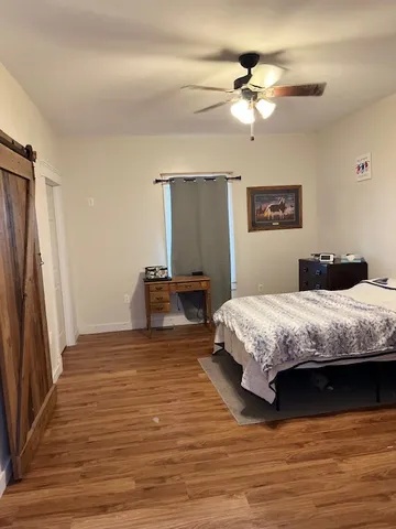 a bedroom with a large bed chandelier and a window