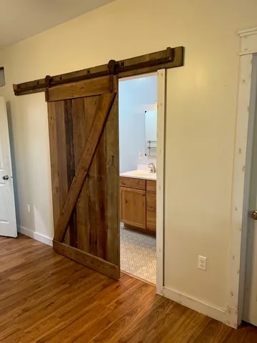a view of a hallway with wooden floor and staircase