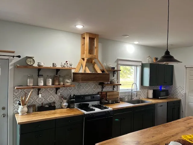a kitchen with granite countertop a sink stainless steel appliances and cabinets
