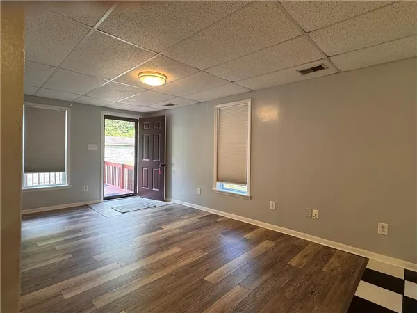 a view of an empty room with window and wooden floor