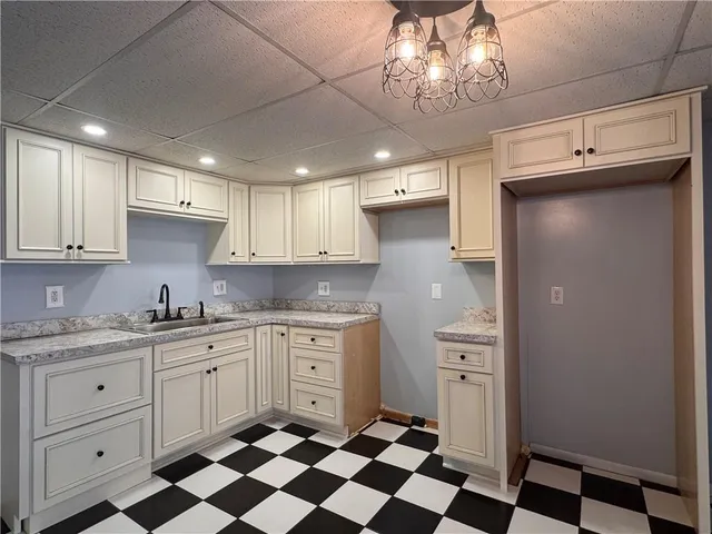 a kitchen with a sink a refrigerator and cabinets