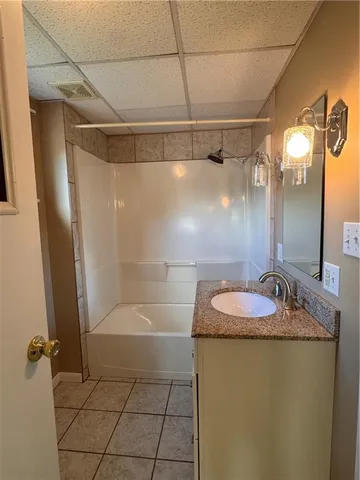 a bathroom with a granite countertop shower sink and mirror