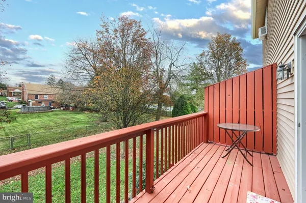 a balcony with wooden floor and trees in the background