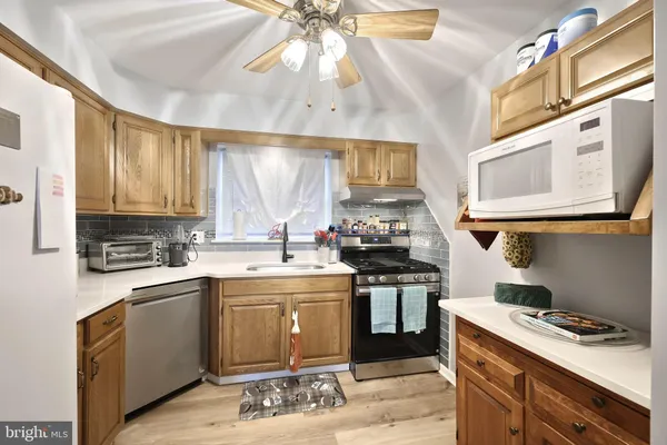 a kitchen with stainless steel appliances a sink stove and cabinets
