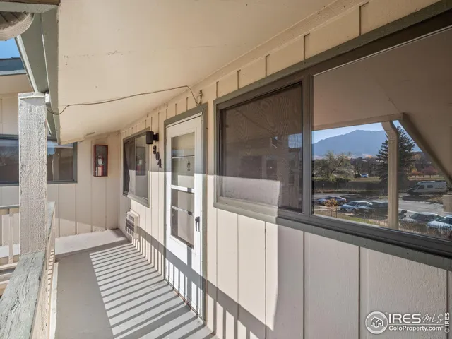 a view of a balcony with wooden floor and iron stairs