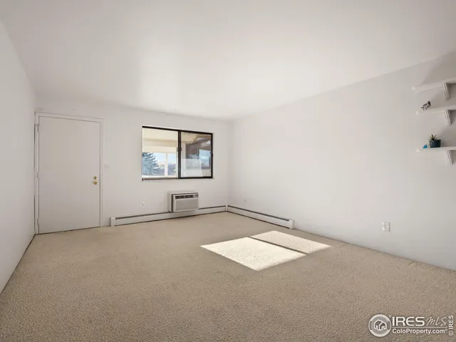 an empty room with windows and mirror