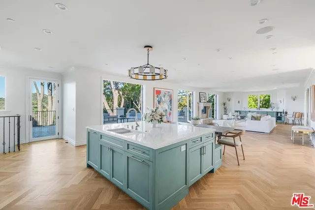 a kitchen with a dining table chairs and white cabinets