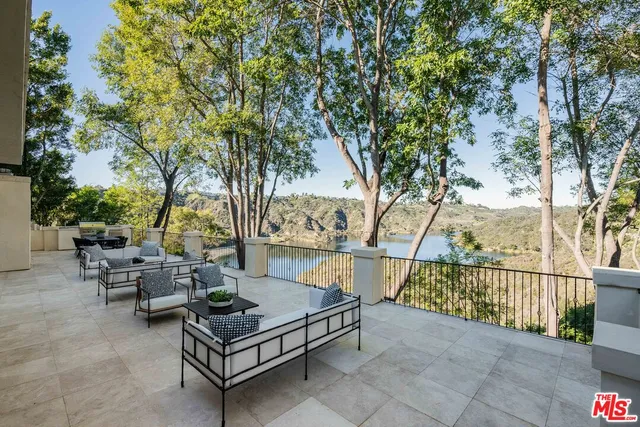 a view of a patio with couches table and chairs and potted plants