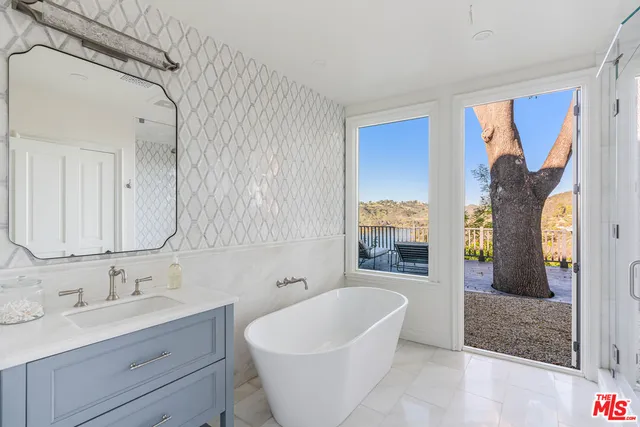 a bedroom with a bed lamp and a large window