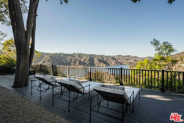a balcony with wooden floor table and chairs