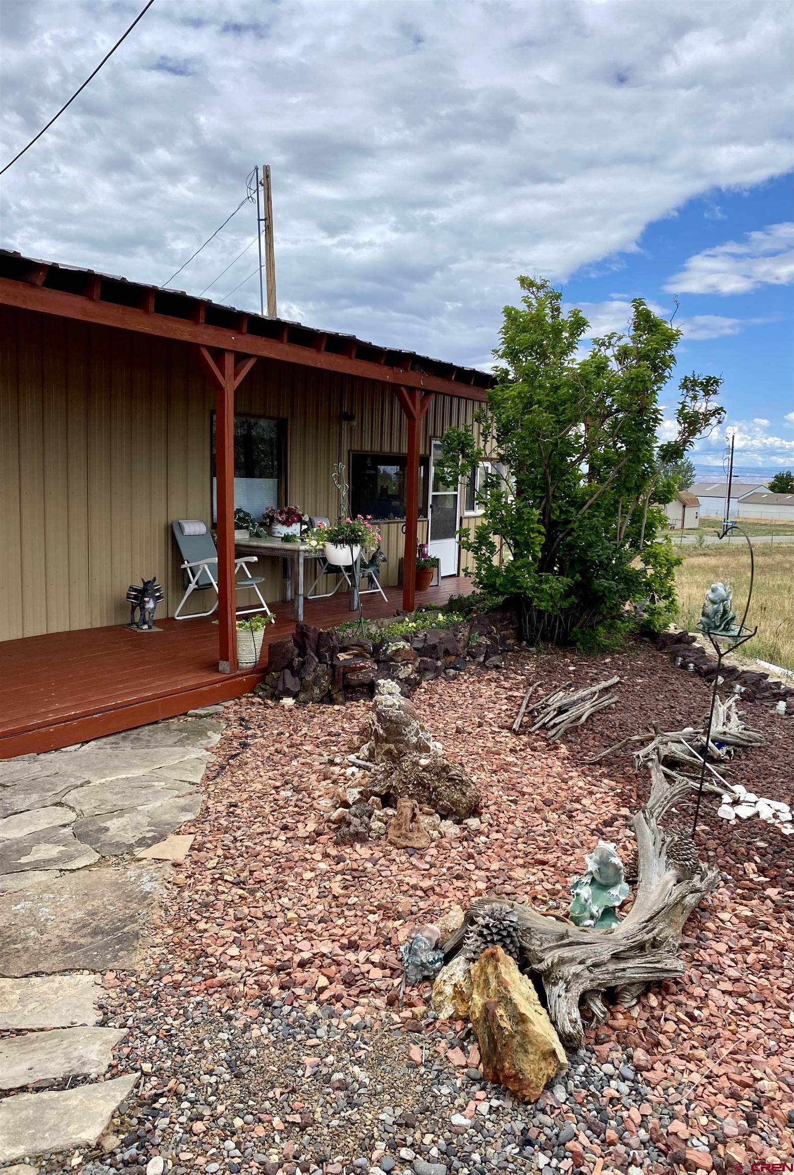 21159 Nowhere Road Eckert, CO 81418 - Photo 17 of 27 a front view of a house with garden and sitting area
