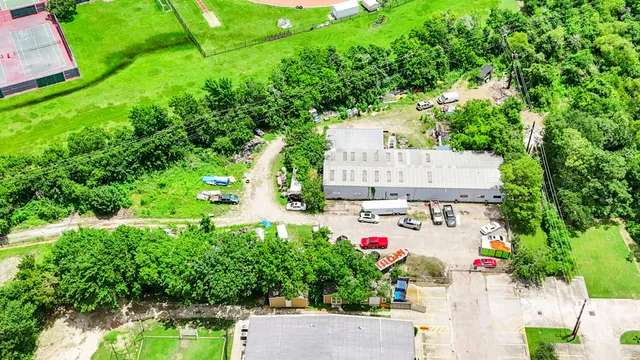 an aerial view of residential house with outdoor space and trees all around