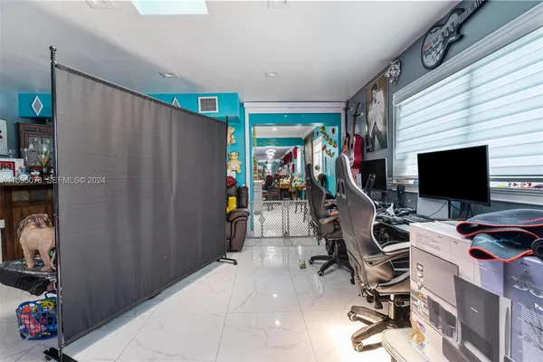 a view of a workspace with furniture and a flat screen tv