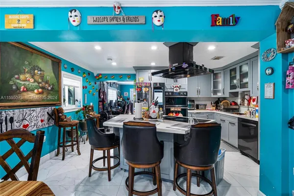 a room with stainless steel appliances lots of furniture and toys